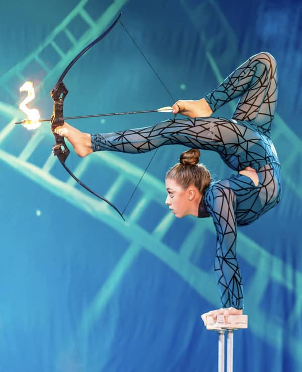 contortion contortionist does archery during a performance